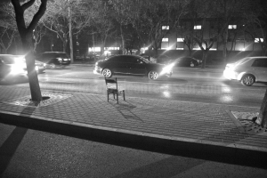 Una silla solitaria esperando a su dueno al pie de una calle de Pekín